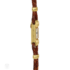 An Art Deco gold cocktail watch centered by a rectangular fa...