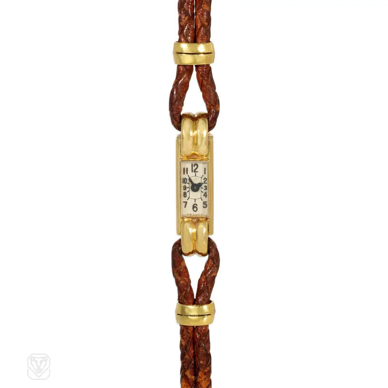 An Art Deco gold cocktail watch centered by a rectangular fa...