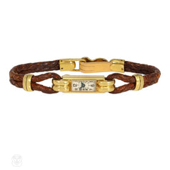 An Art Deco gold cocktail watch centered by a rectangular fa...