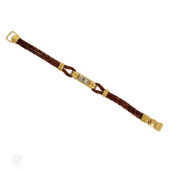 An Art Deco gold cocktail watch centered by a rectangular fa...