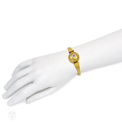 Antique gold bangle with central diamond and sapphire flower