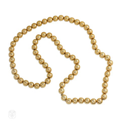 Gold bead necklace of adjustable length