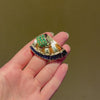 French Retro scroll brooch with sapphires and emerald