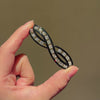 An Art Deco enamel and diamond infinity brooch
